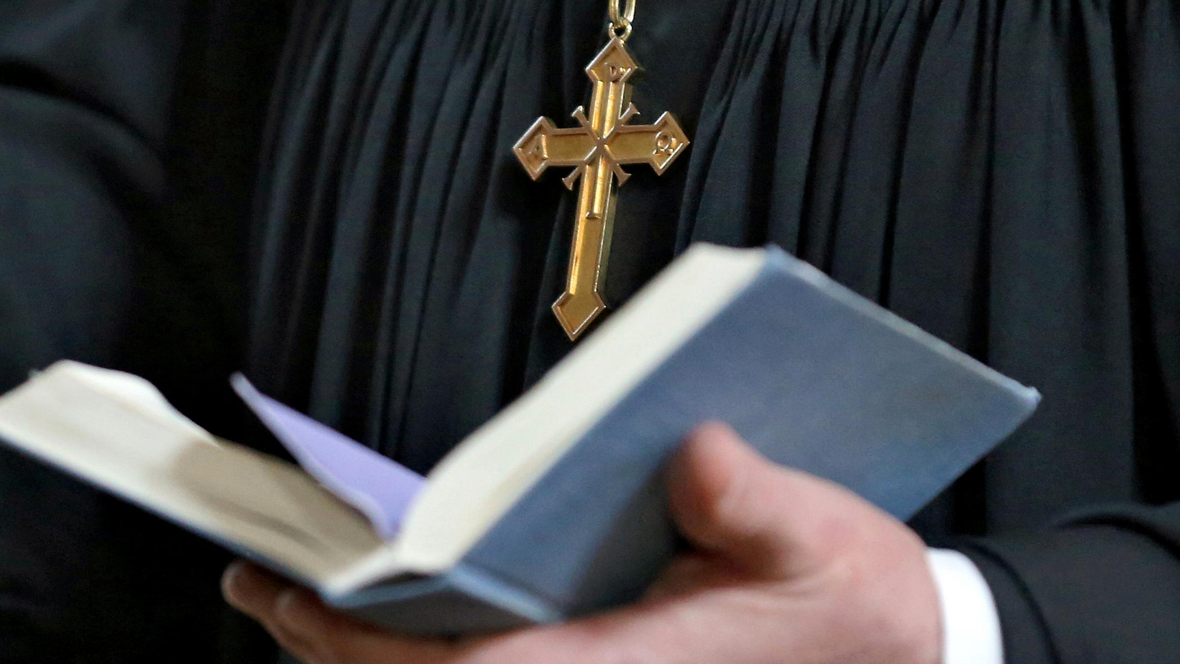 Pfarrer hält Bibel in der Hand