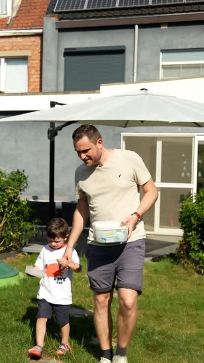 Es ist eine Familie im Garten zu sehen mit zwei kleinen Kindern.
