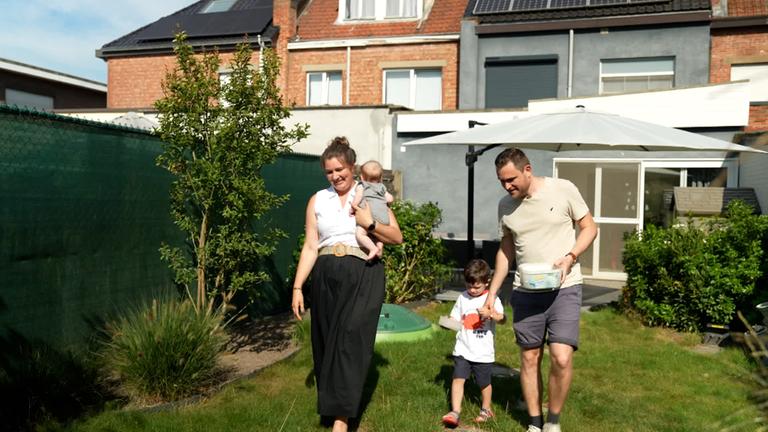 Es ist eine Familie im Garten zu sehen mit zwei kleinen Kindern.