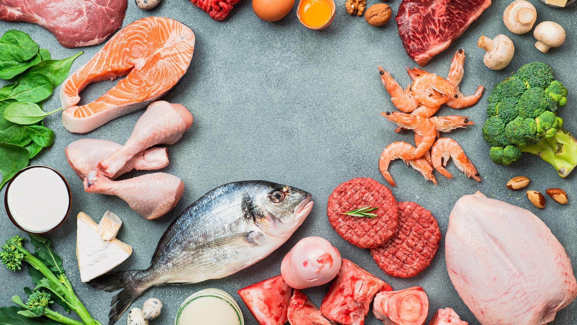 Fleisch, Fisch und Gemüse auf einem Tisch verteilt.