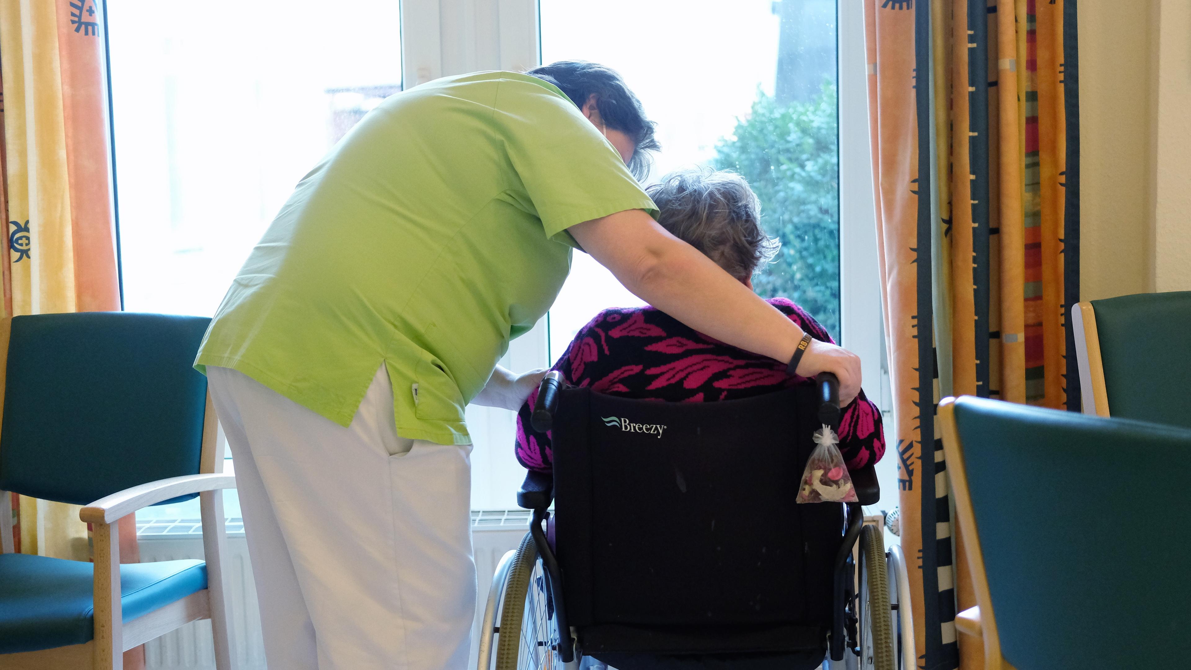 Pflegerin spricht mit Bewohnerin eines Altenheims
