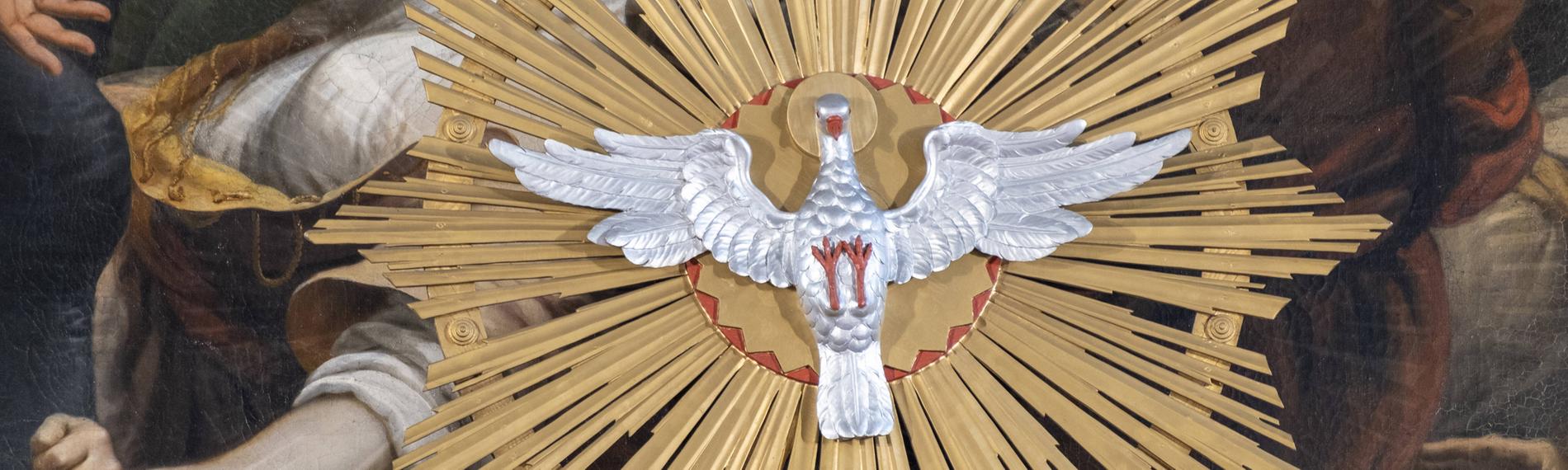 Pfingsttaube vor dem Altarbild im Hochaltar der Stiftspfarrkirche St. Philipp und Jakob in Altötting.