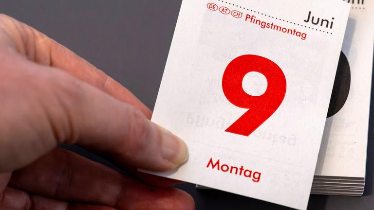 Montag 9.Juni 2025, Pfingstmontag, Frau reisst das Kalenderblatt ab. Aufgenommen am 7.02.2025