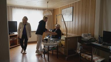 Pflegekraft Lucy beim Besuch eines Patienten