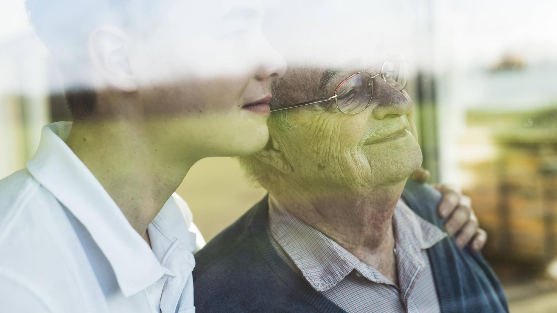 Junger und alter Mann Arm in Arm