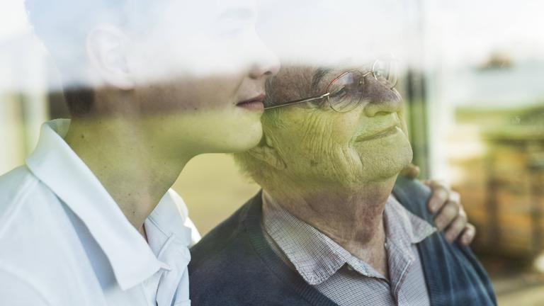 Junger und alter Mann Arm in Arm