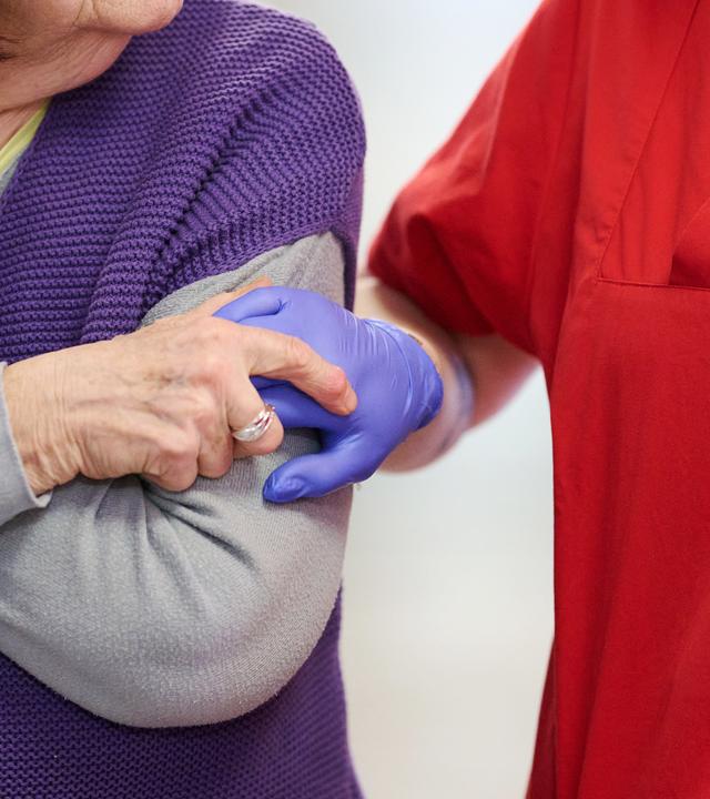 12.03.2025, Nordrhein-Westfalen, Essen: Eine Pflegekraft nimmt im DRK-Pflegezentrum Solferino eine Bewohnerin an der Hand.