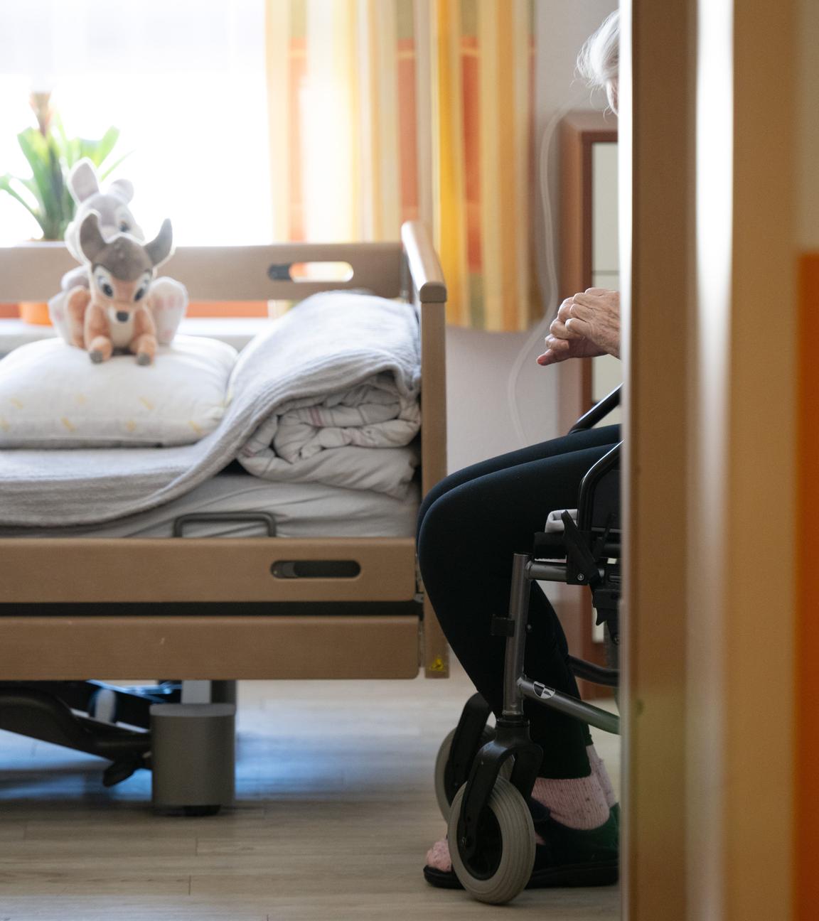 Ein Bewohner sitzt in einem Altenheim in seinem Zimmer in einem Rollstuhl.
