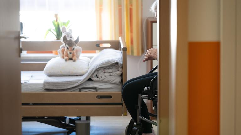 Ein Bewohner sitzt in einem Altenheim in seinem Zimmer in einem Rollstuhl.