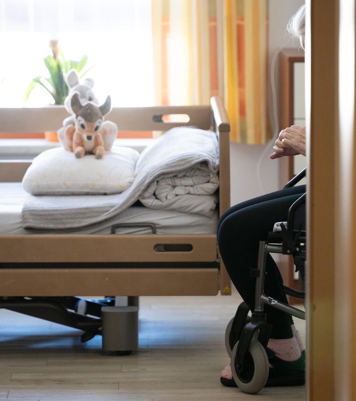 Ein Bewohner sitzt in einem Altenheim in seinem Zimmer in einem Rollstuhl. 