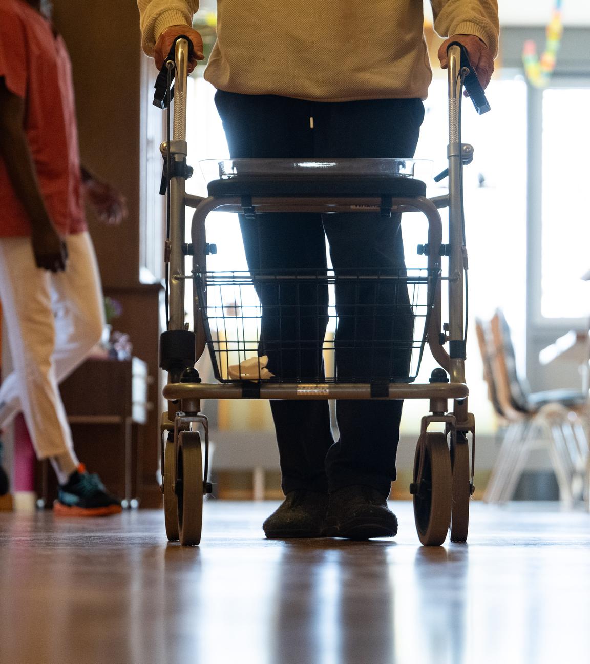 Symbolbild: Bewohner eines Pflegeheims mit Rollator in einem Gang