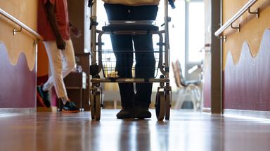 Symbolbild: Bewohner eines Pflegeheims mit Rollator in einem Gang