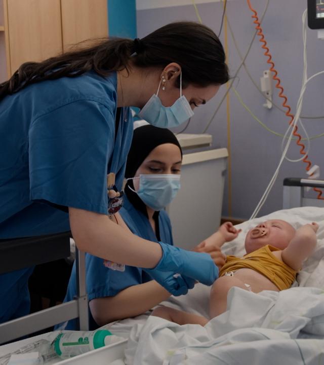Pflegerinnen am Krankenbett von Kindern