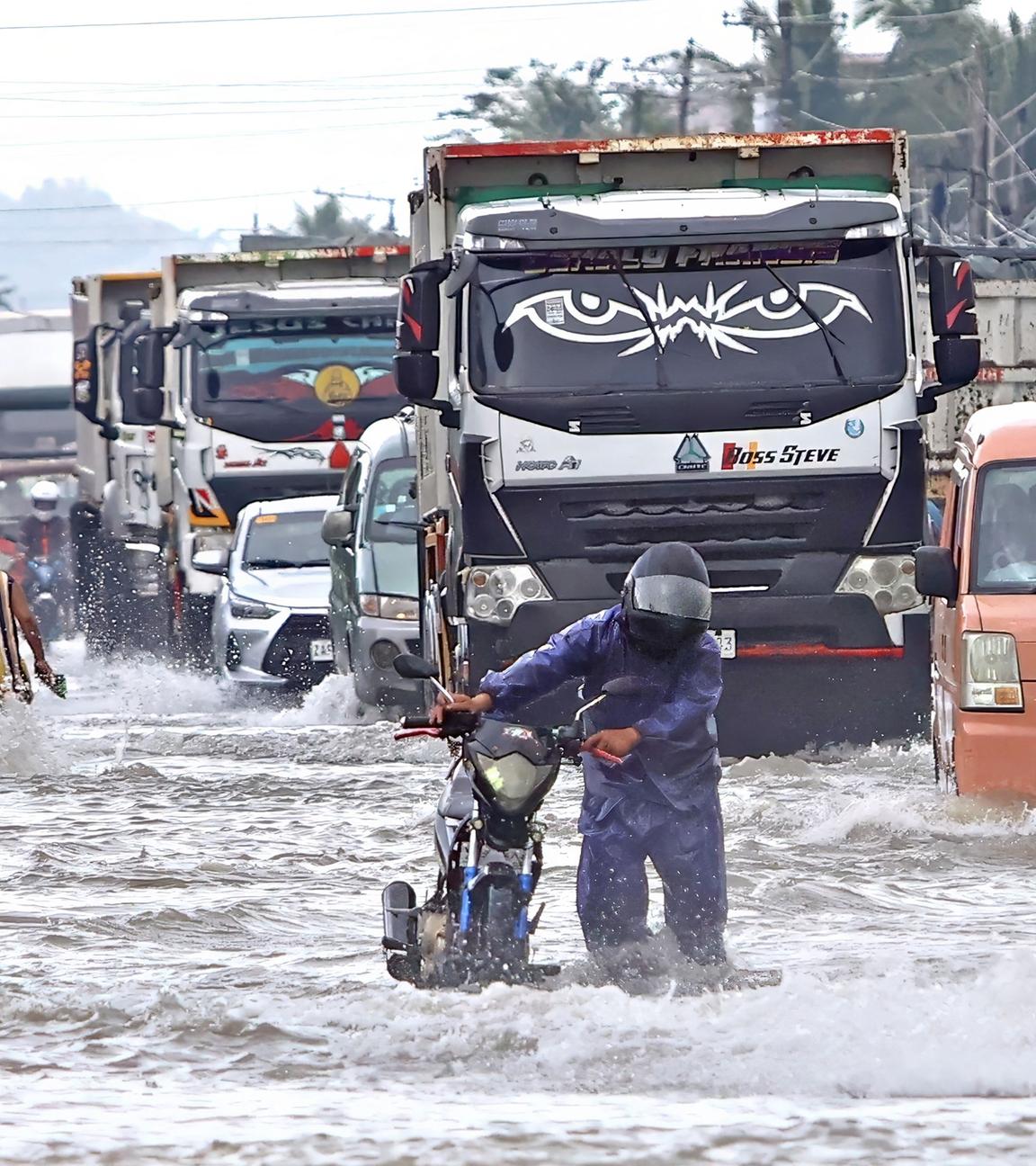 Der Taifun "Fung-Wong" auf den Philippinen ist zu sehen, welcher eine Straße mit anhaltendem Verkehr überschwemmt.
