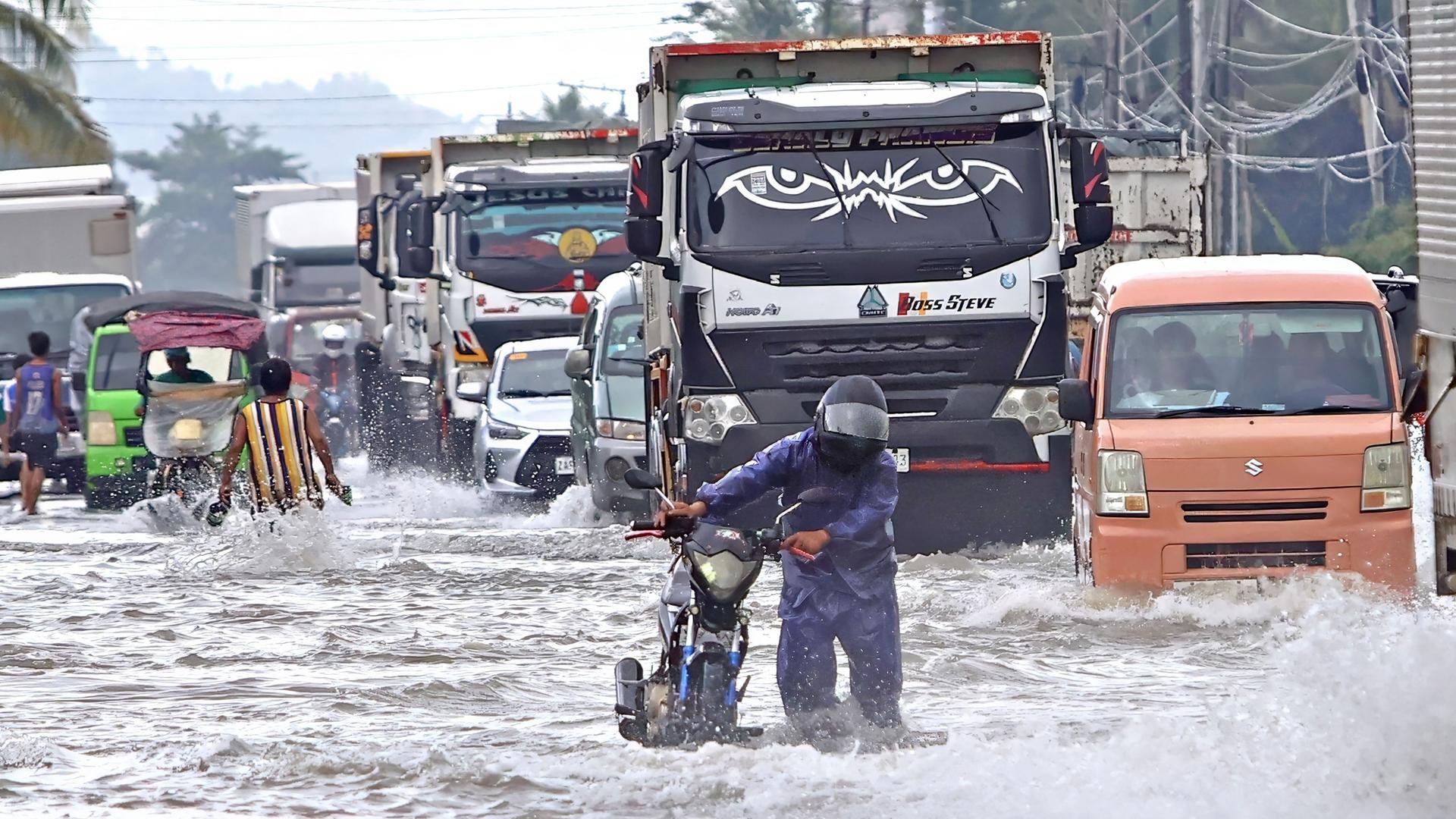 Der Taifun "Fung-Wong" auf den Philippinen ist zu sehen, welcher eine Straße mit anhaltendem Verkehr überschwemmt.