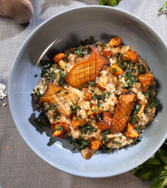 Pilzrisotto mit Kräutern serviert auf einem Teller.