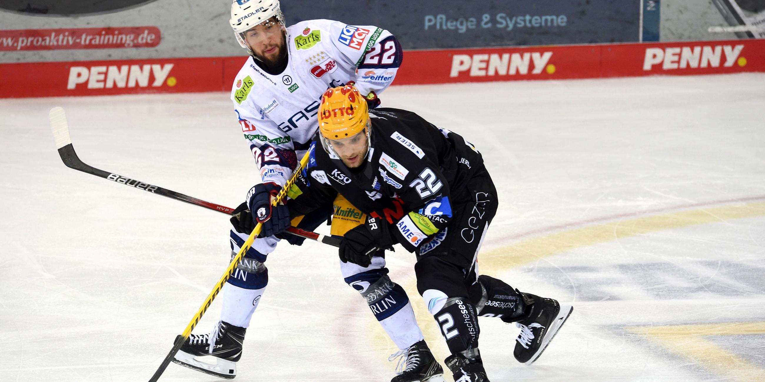 Bremerhavens Vladimir Eminger (r) kämpft gegen Berlins Tobias Eder um den Puck.