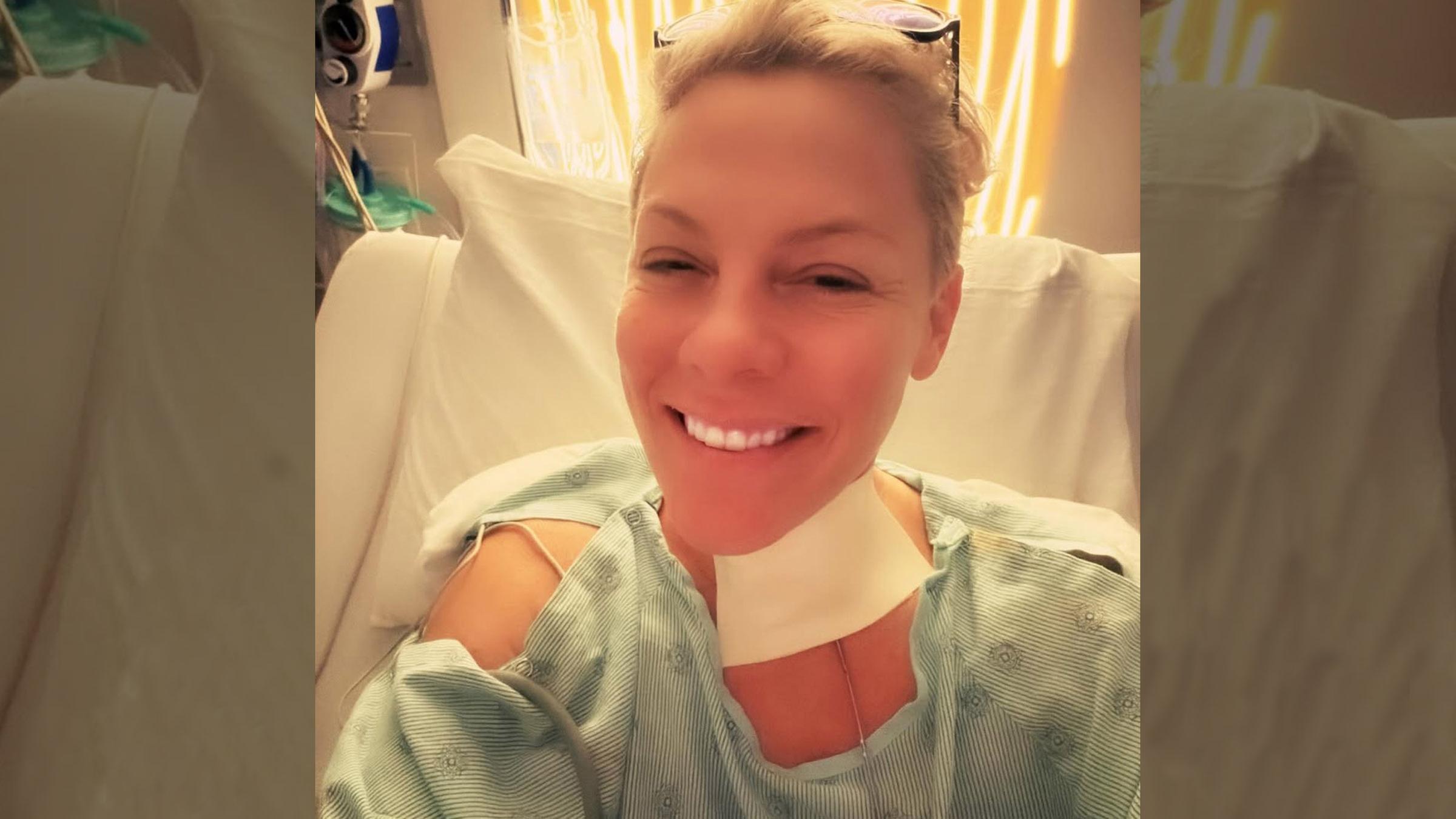 Die Sängerin Pink posiert lächelnd in einem Krankenhausbett, nachdem sie operiert wurde.
