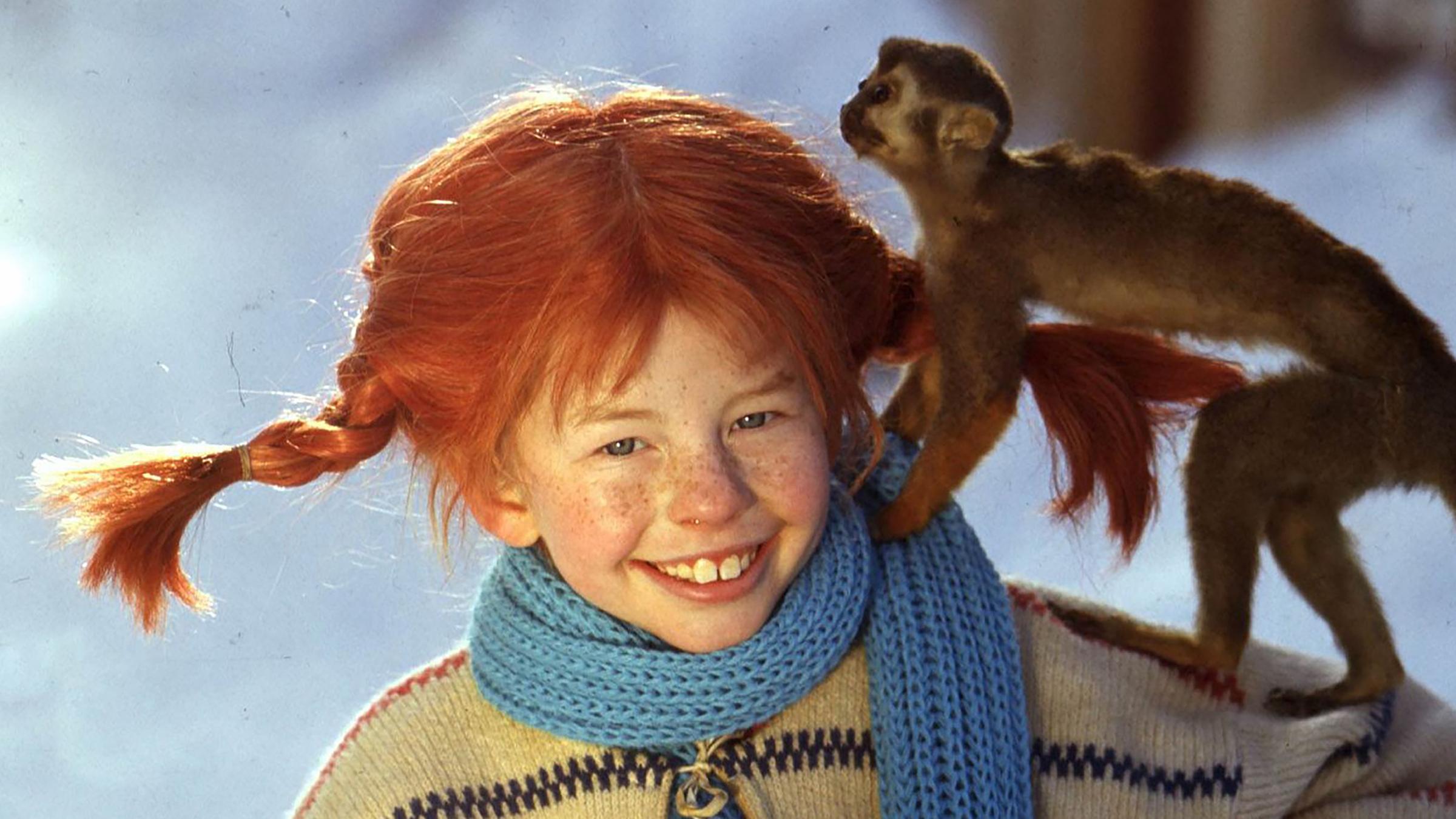 Pippi Langstrumpf (Inger Nilsson) steht im Schnee mit ihrem Affen Herr Nilsson auf dem Arm.