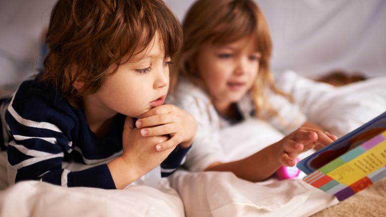 ein Junge und ein Mädchen lesen in einem Buch