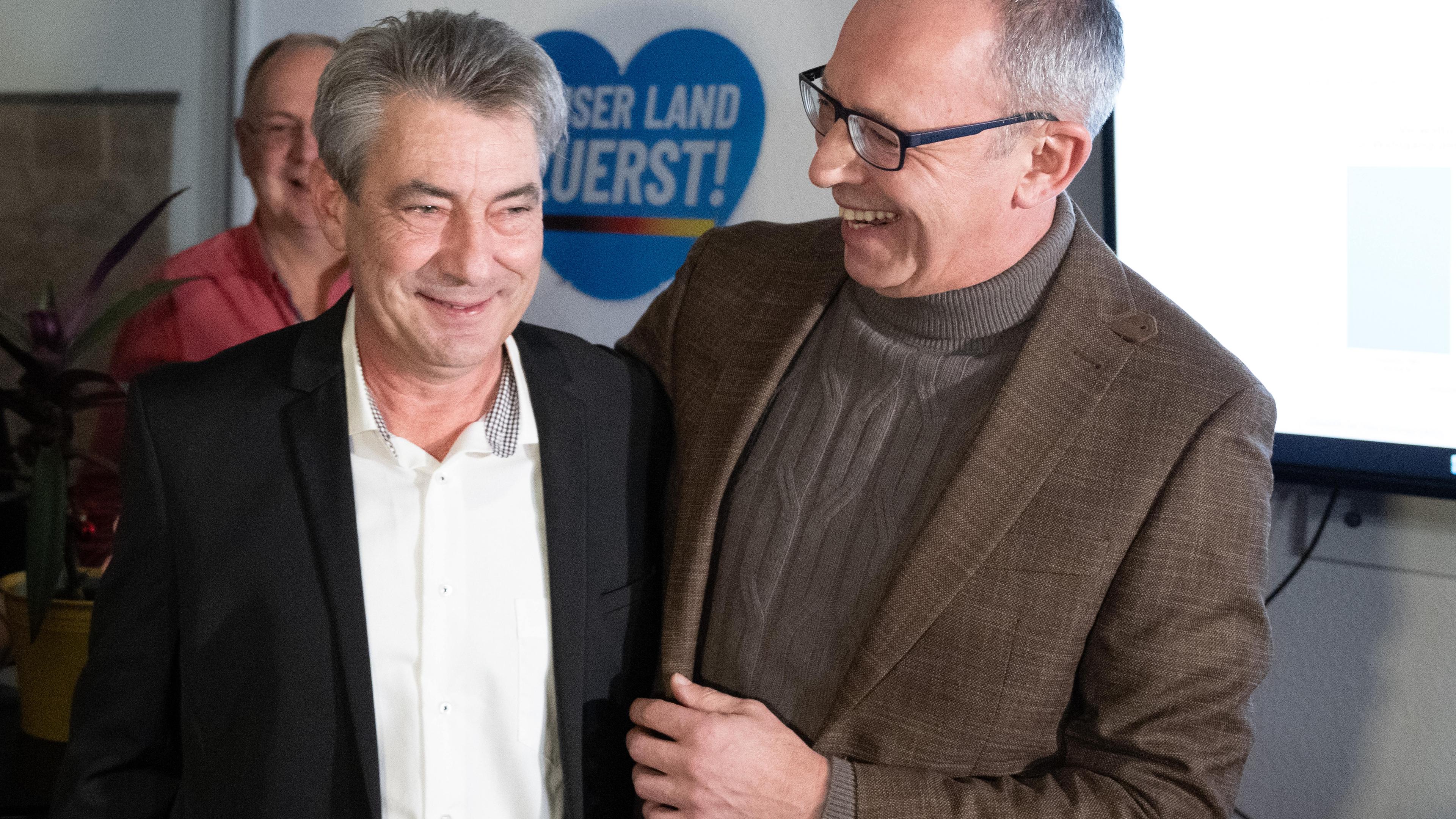 17.12.2023, Sachsen, Pirna: Tim Lochner (l), der für die Oberbürgermeisterwahl von der AfD aufgestellte Kandidat, und Jörg Urban, Vorsitzender der AfD in Sachsen, freuen sich während der Wahlparty ihrer Partei.