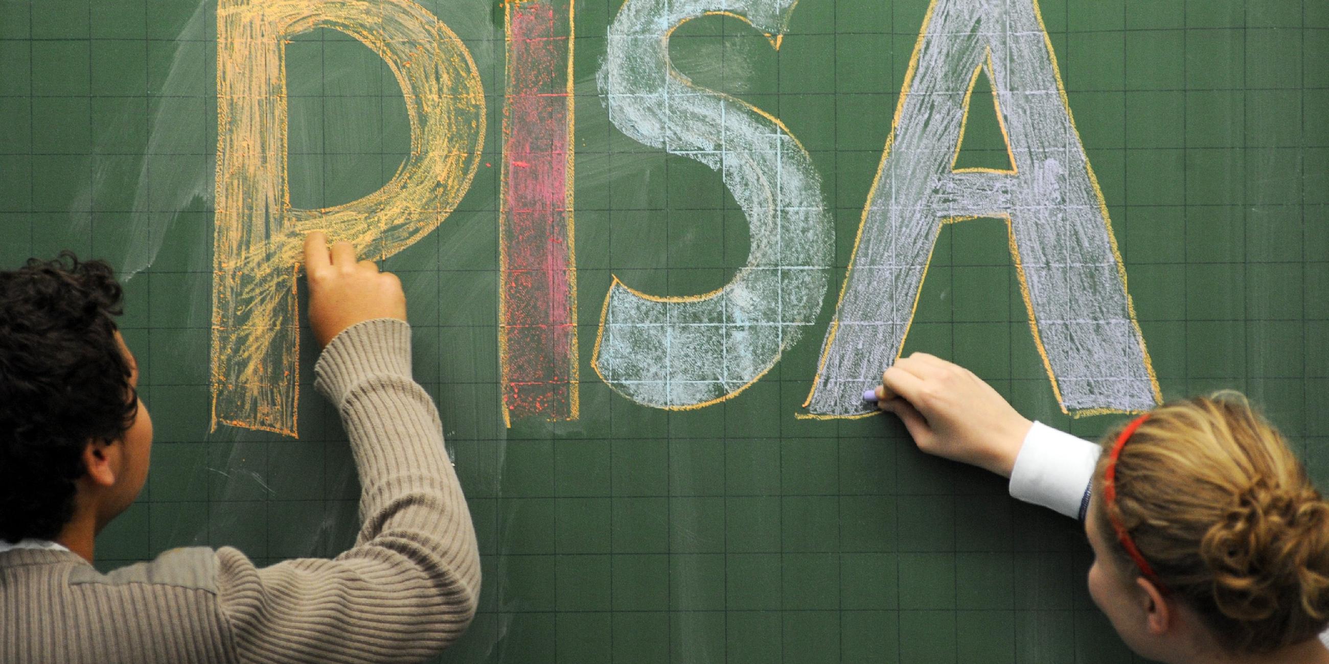 schueler schreiben "pisa" an eine tafel