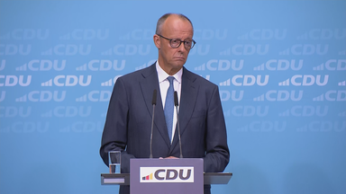 Bundeskanzler Friedrich Merz bei der Pressekonferenz nach der Wahl in Sachsen-Anhalt. Er steht vor einer blauen wand mit "CDU" Aufschriften.