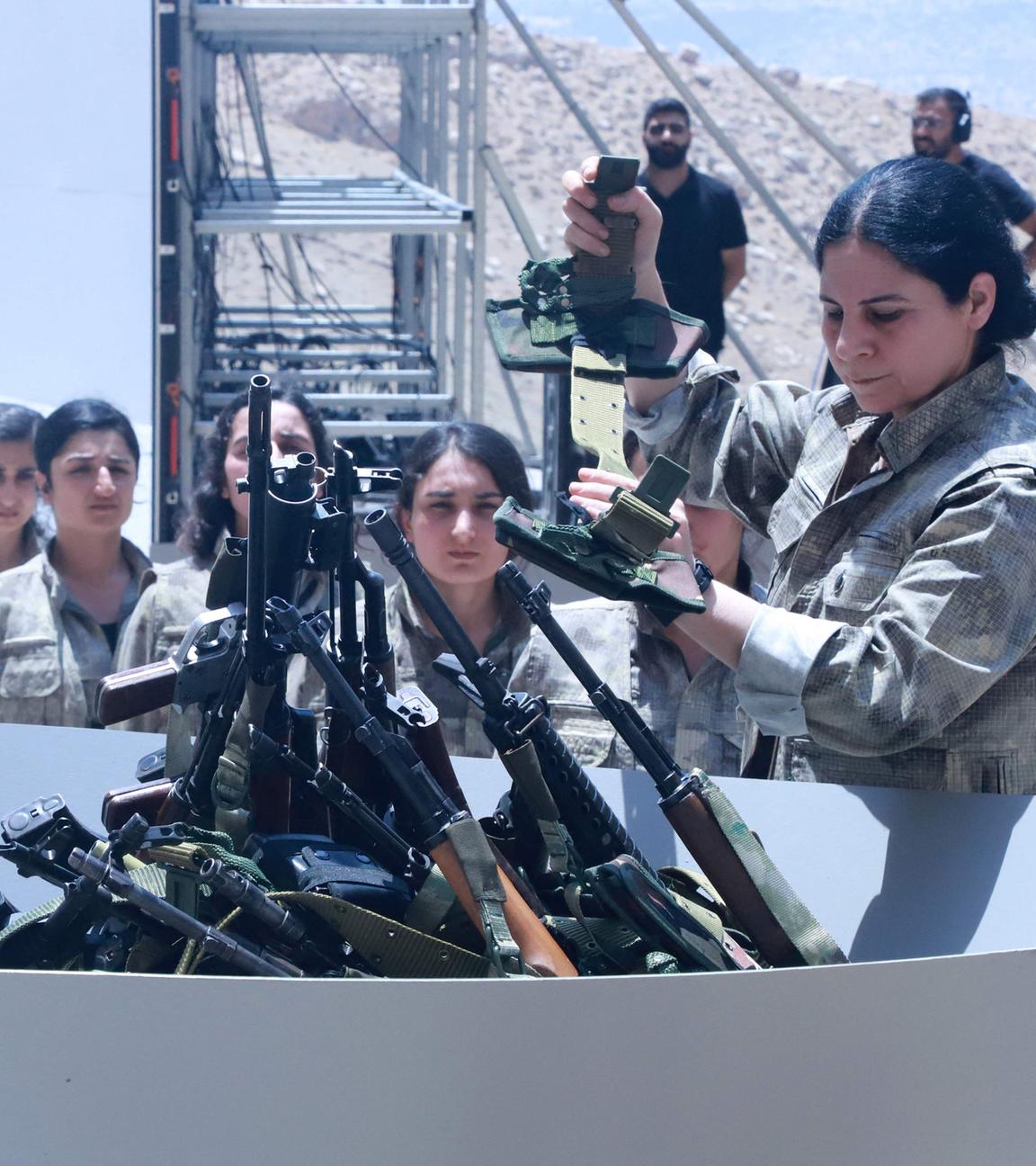 Kämpfer der Arbeiterpartei Kurdistans (PKK) stellen sich am 11. Juli 2025 bei einer Zeremonie in Sulaimaniyah, der irakischen Autonomen Region Kurdistan, auf, um ihre Waffen in eine Grube zu werfen. 