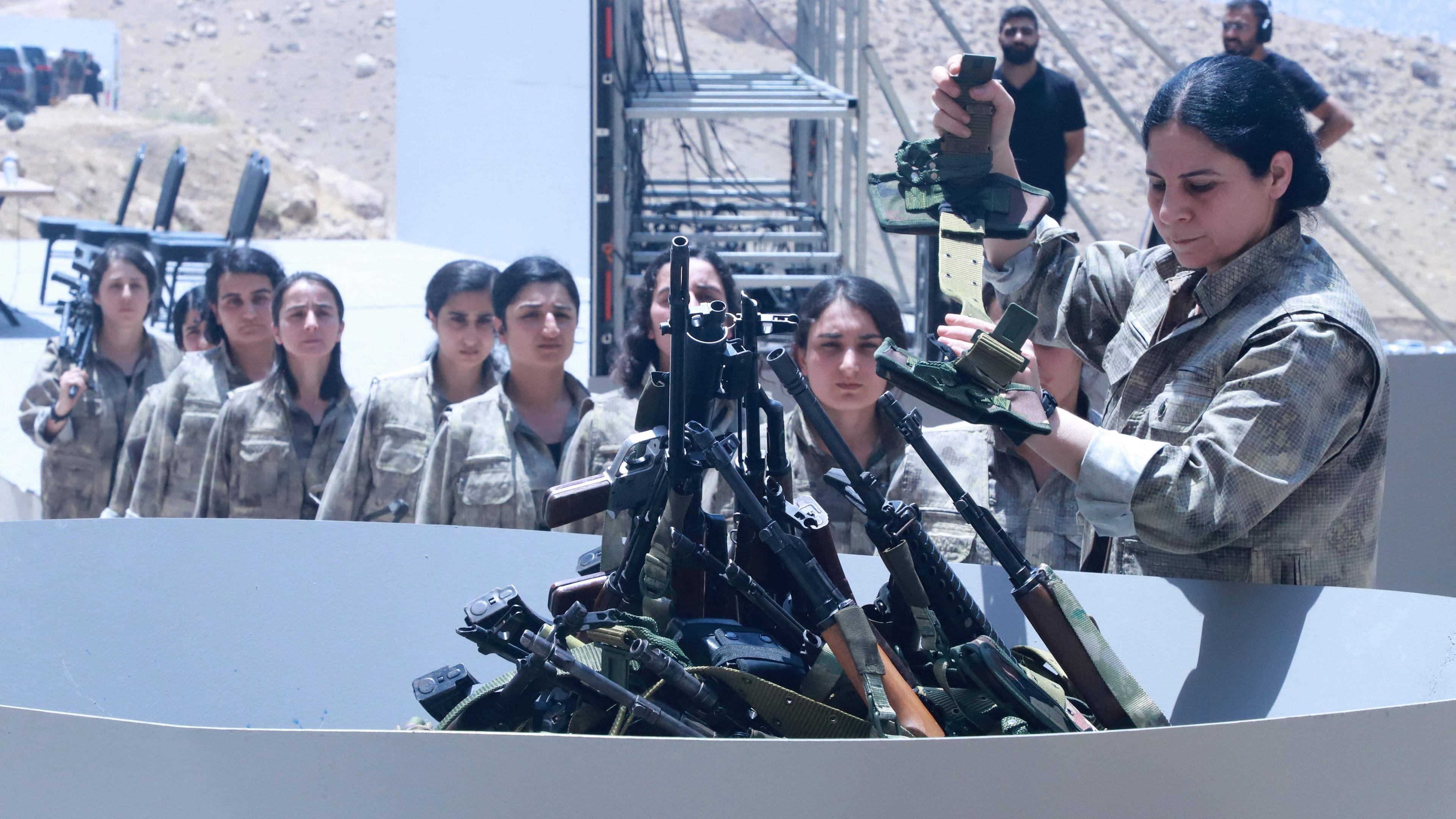 Kämpfer der Arbeiterpartei Kurdistans (PKK) stellen sich am 11. Juli 2025 bei einer Zeremonie in Sulaimaniyah, der irakischen Autonomen Region Kurdistan, auf, um ihre Waffen in eine Grube zu werfen. 
