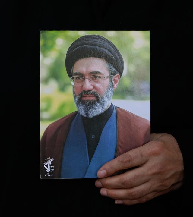 Eine iranische Frau hält am 04.08.2026 in Teheran, Iran, ein Plakat des iranischen Obersten Führers Ajatollah Modschtaba Chamenei in den Händen.