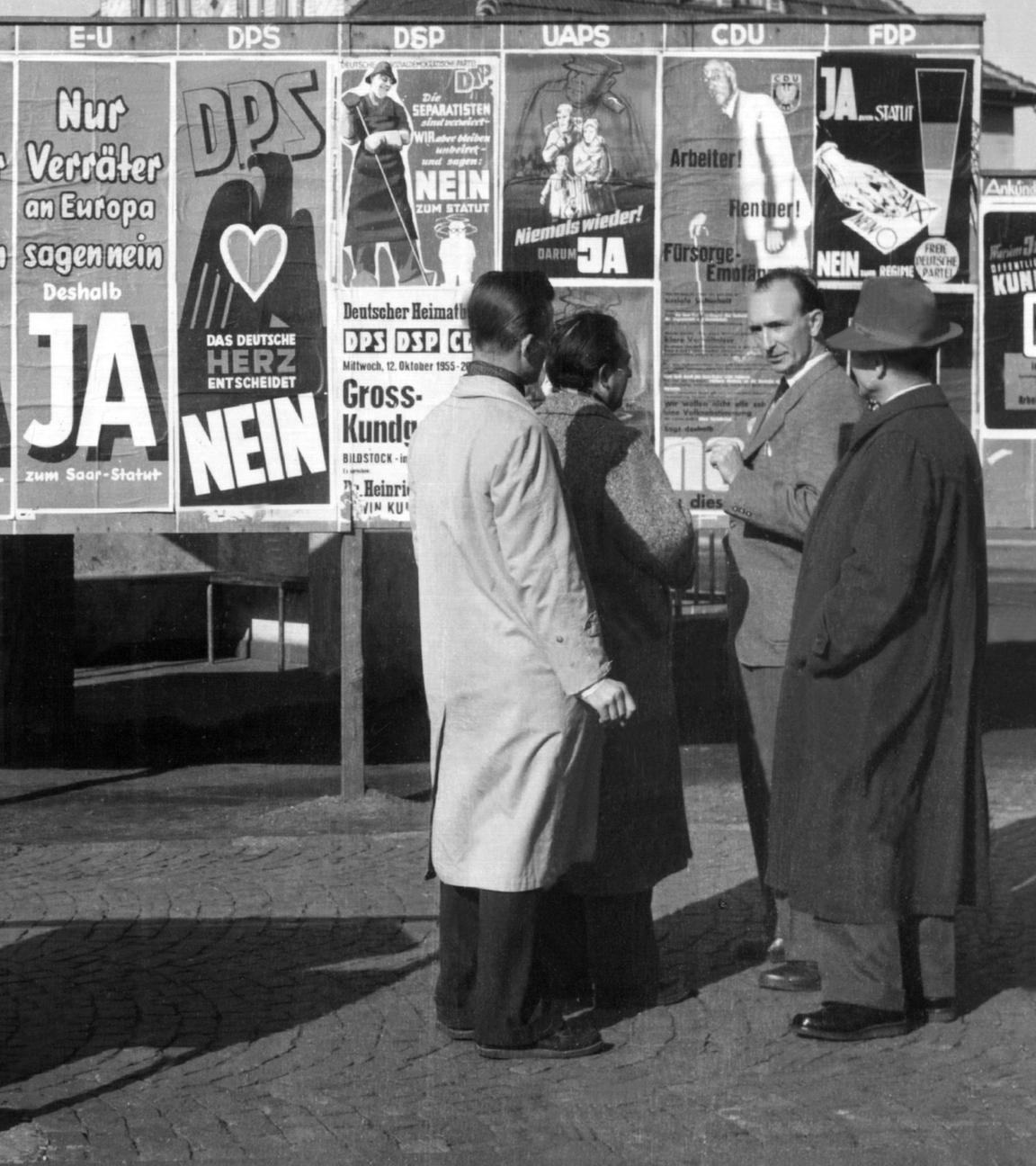 Rege Diskussionen führen Passanten am 20. Oktober 1955 in Beckingen (saarland) vor einer Anschlagtafel, auf der alle zugelassenen Parteien ihr für und wider das zwischen Paris und Bonn vereinbarte "Europaeische Saarstatut" propagieren