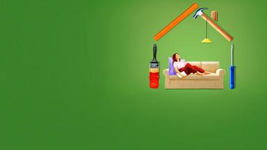 Eine Frau sitzt auf einem Sofa, das in einem schematisch aus Werkzeugen gebauten Haus steht