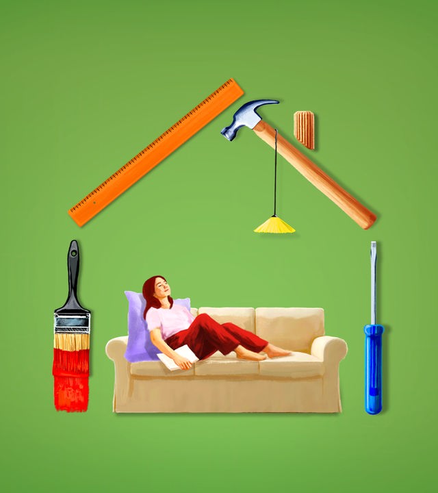 Eine Frau sitzt auf einem Sofa, das in einem schematisch aus Werkzeugen gebauten Haus steht