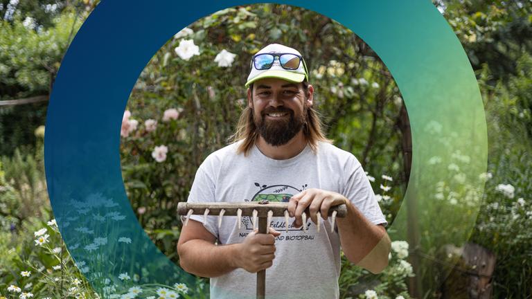 Mann mit Harke im Garten