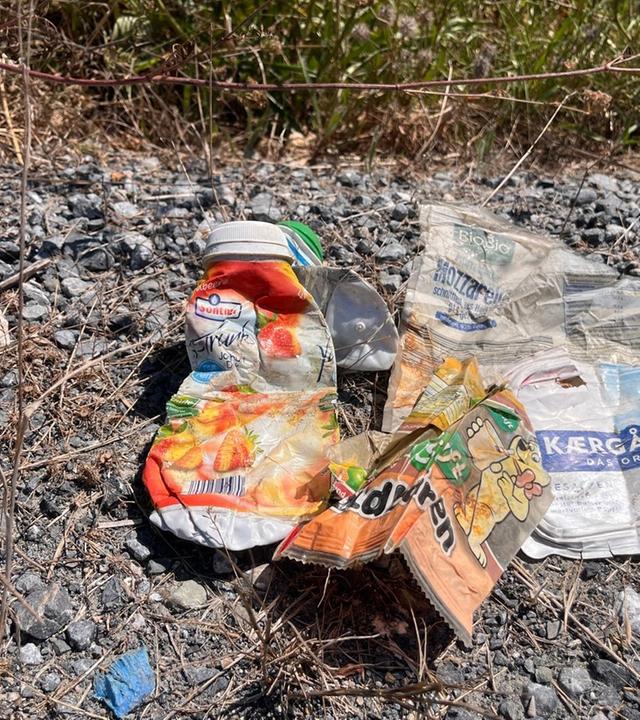 Plastikmüll liegt auf Schotter.
