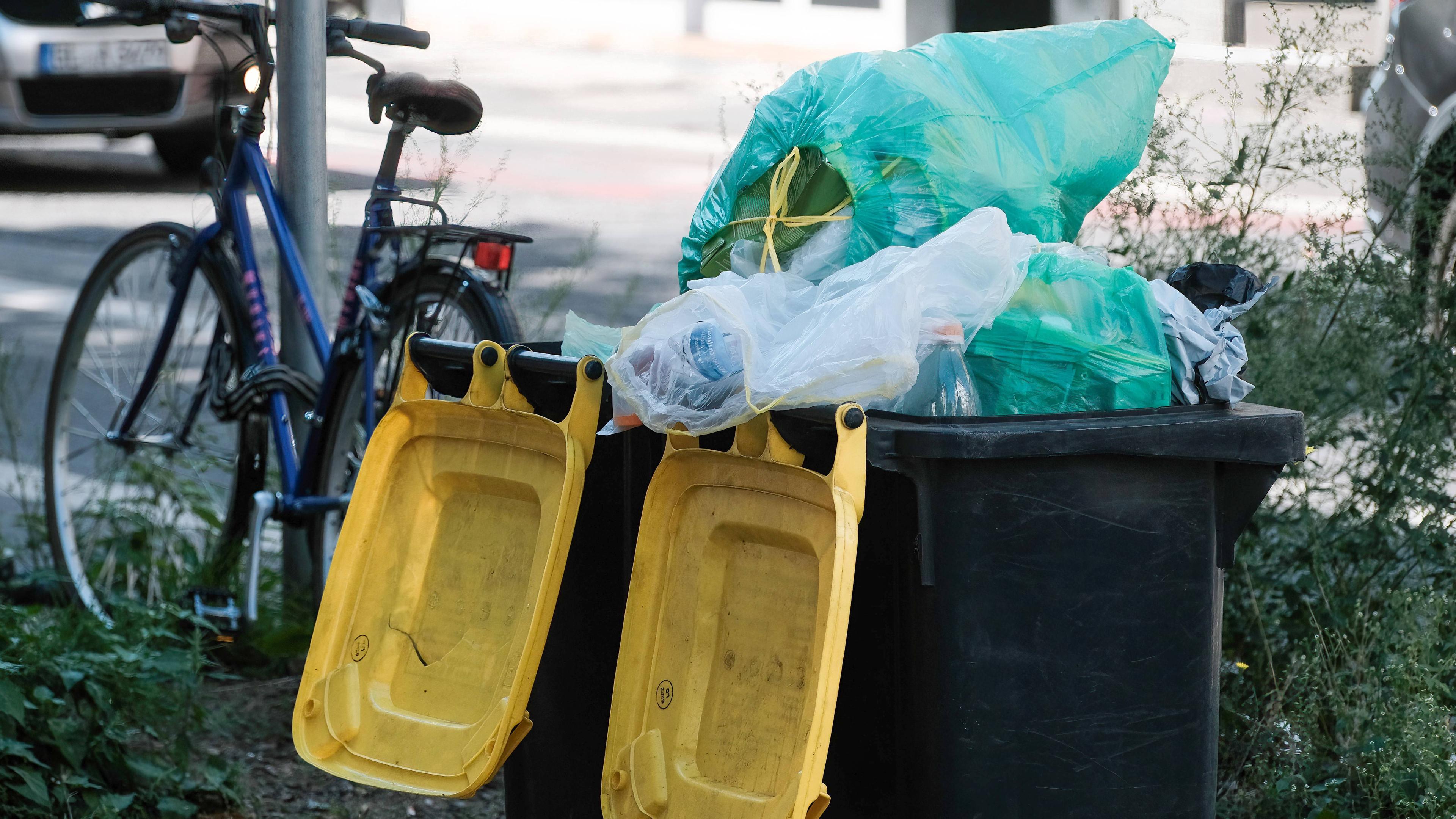 Düsseldorf 28.08.2024 - Zwei mit Plastikmüll überfüllt Gelbe Tonnen stehen auf der Straße