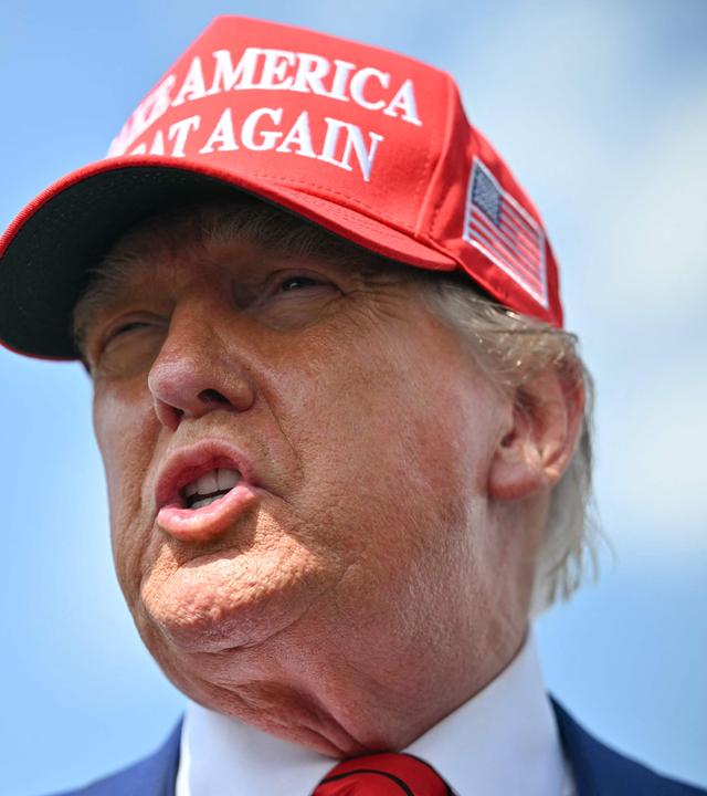 Donald Trump in einer ziemlich nahen Einstellung mit roter Mütze auf dem Kopf.