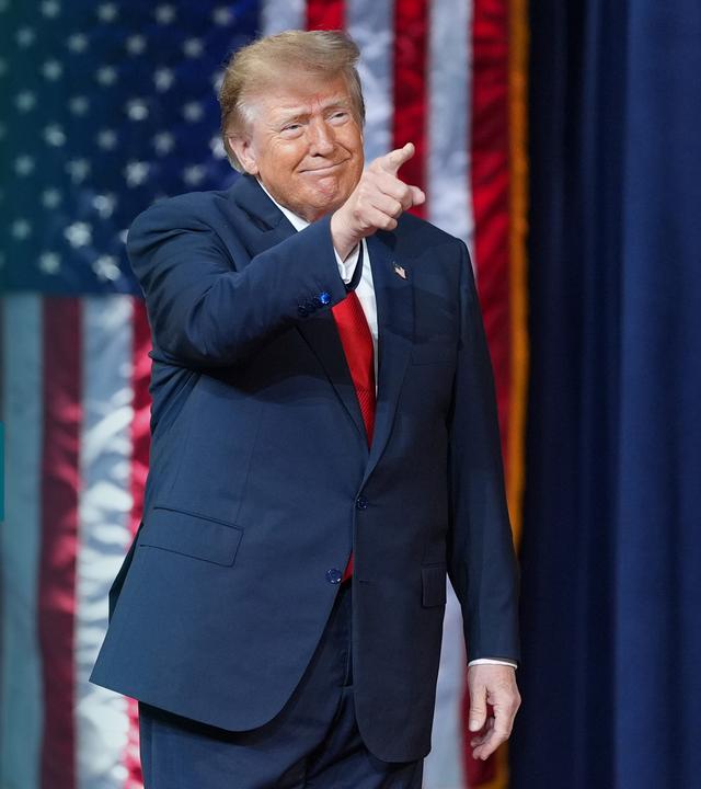 Donald Trump zeigt in Richtung Zuschauer. Links daneben ist das Logo vom Trump Effekt Podcast zu sehen.