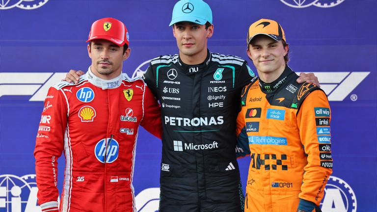 Drei Rennfahrer stehen nebeneinander. Links Ferrari Fahrer Leclerc, in der Mitte Mercedes Fahrer Russell und rechts McLaren Pilot Piastri