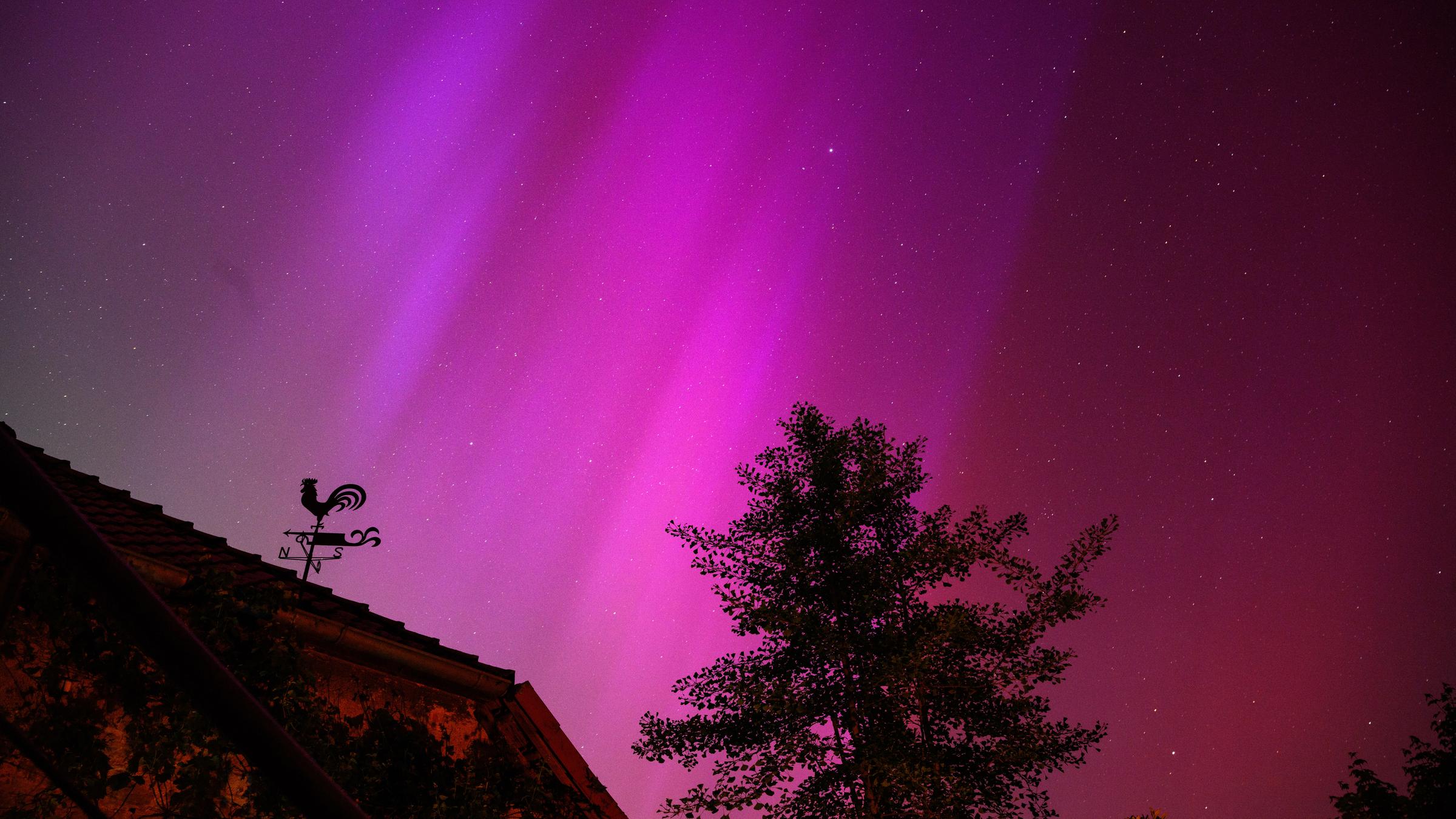 Niedersachsen, Eldagsen: Polarlichter sind hinter einem Wetterhahn am Kloster Wülfinghausen bei Eldagsen südlich von Hannover zu sehen.