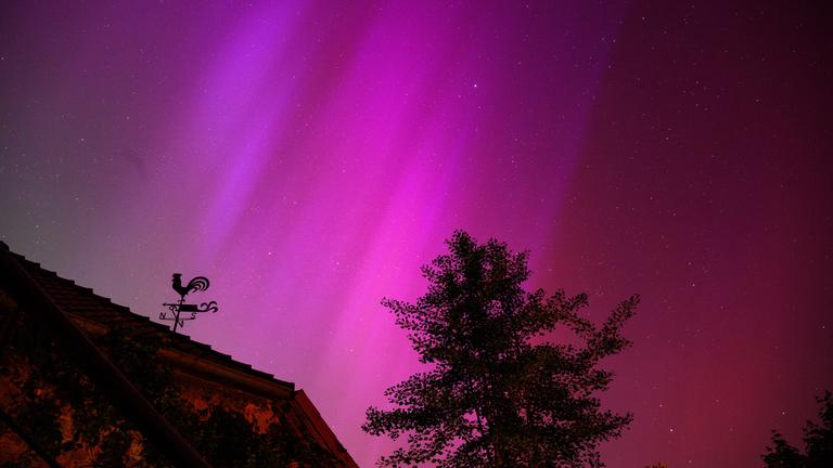 Niedersachsen, Eldagsen: Polarlichter sind hinter einem Wetterhahn am Kloster Wülfinghausen bei Eldagsen südlich von Hannover zu sehen.