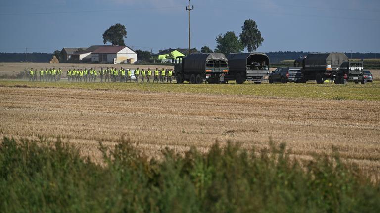 Polnische Einsatzkräfte untersuchen ein Feld, in dem abgeschossene russische Drohnen gefunden wurden.