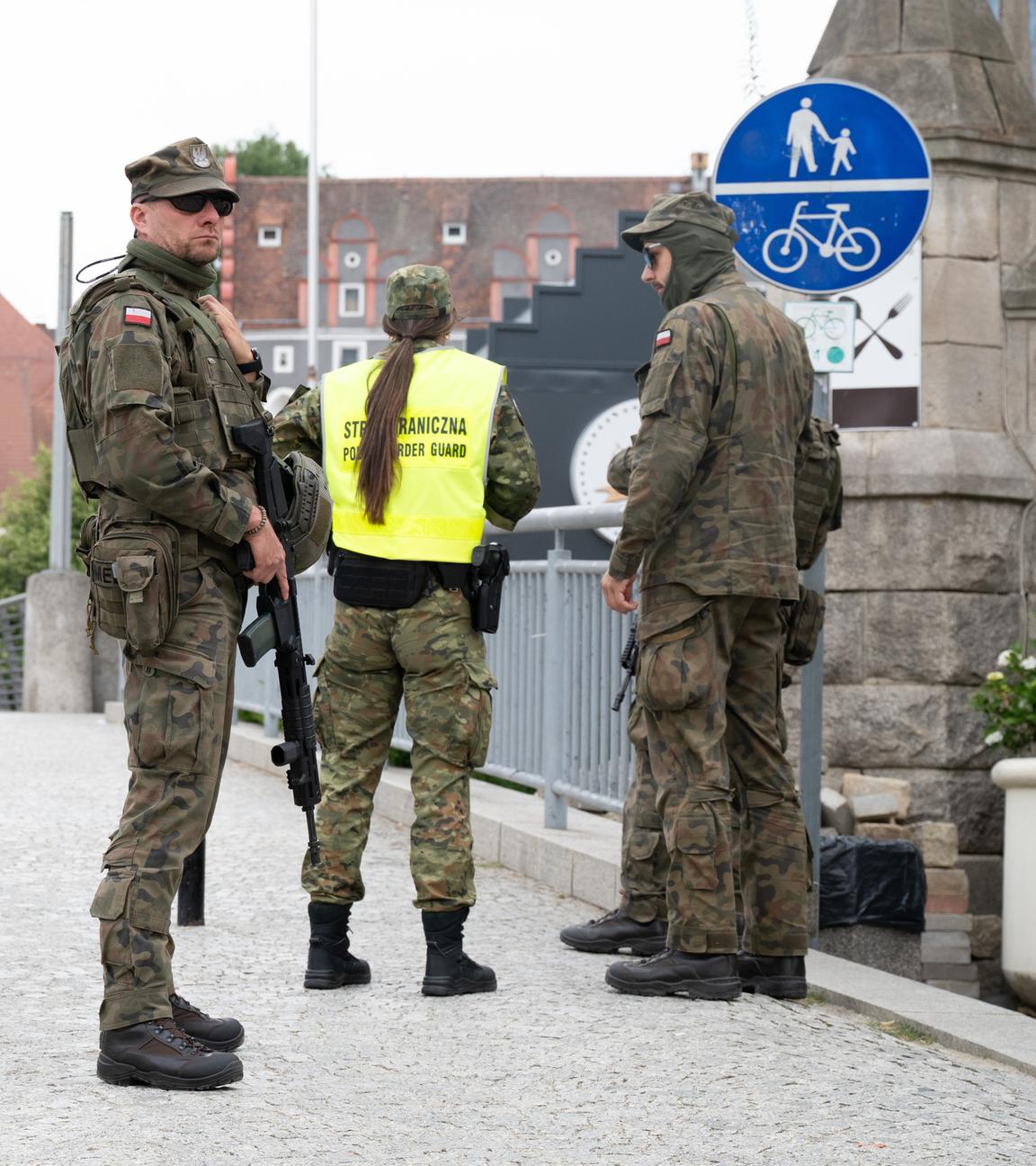 Polnische Grenzschützer stehen auf der polnischen Seite hinter der Altstadtbrücke von Görlitz. 
