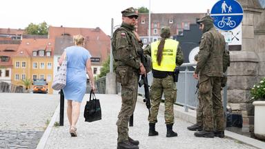 Polnische Grenzschützer stehen auf der polnischen Seite hinter der Altstadtbrücke von Görlitz. 