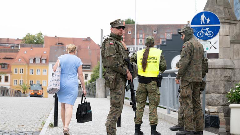 Polnische Grenzschützer stehen auf der polnischen Seite hinter der Altstadtbrücke von Görlitz. 