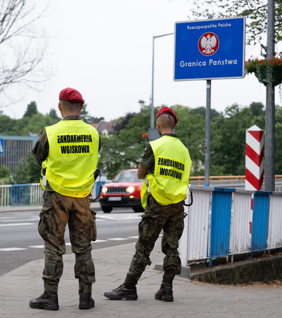 Polnische Grenzschützer stehen auf der polnischen Seite hinter der Stadtbrücke von Görlitz und beobachten den Verkehr.