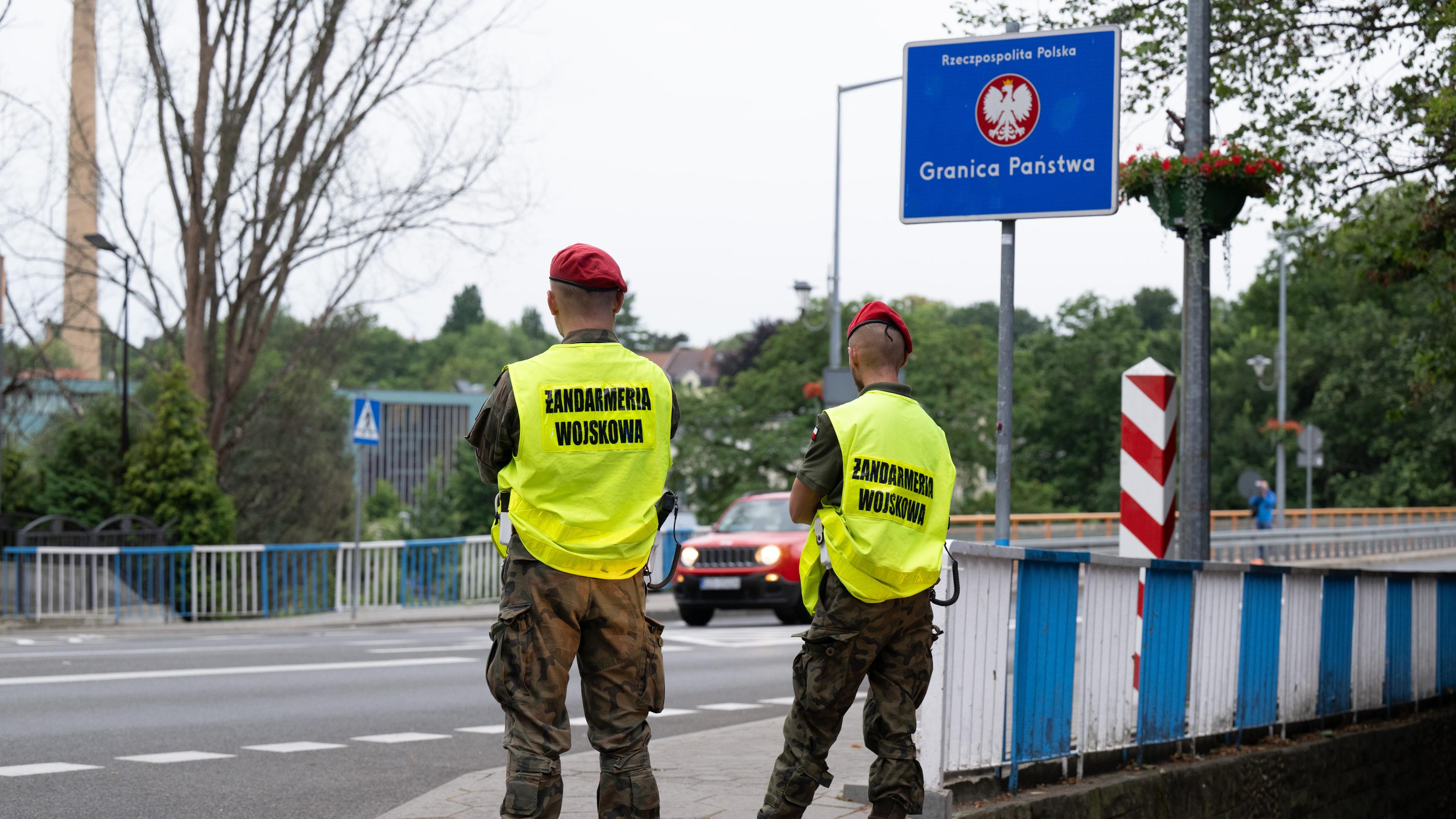 Polnische Grenzschützer stehen auf der polnischen Seite hinter der Stadtbrücke von Görlitz und beobachten den Verkehr.
