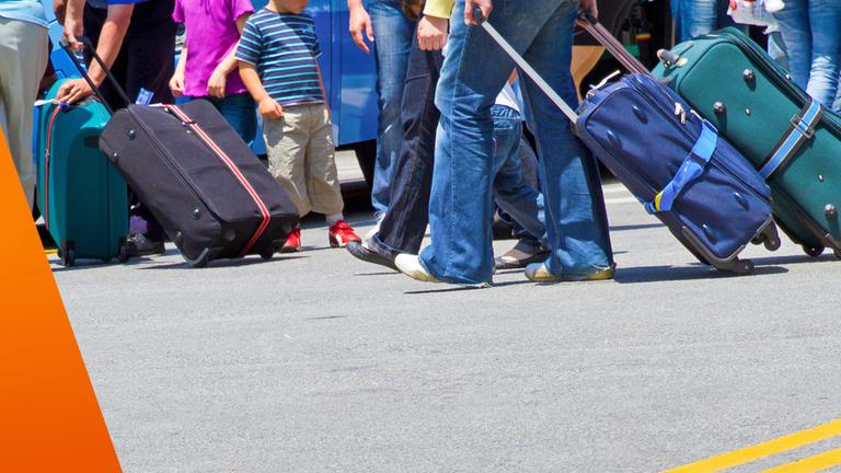 Warum Polen als Fachkräfte Deutschland wieder verlassen: Perspektive von unten: viele Beine und Koffer