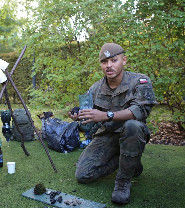 Zwei Soldaten der polnischen Territorialstreitkräfte zeigen im Garten der deutschen Botschaft in Warschau, wie man verdrecktes Wasser reinigt.