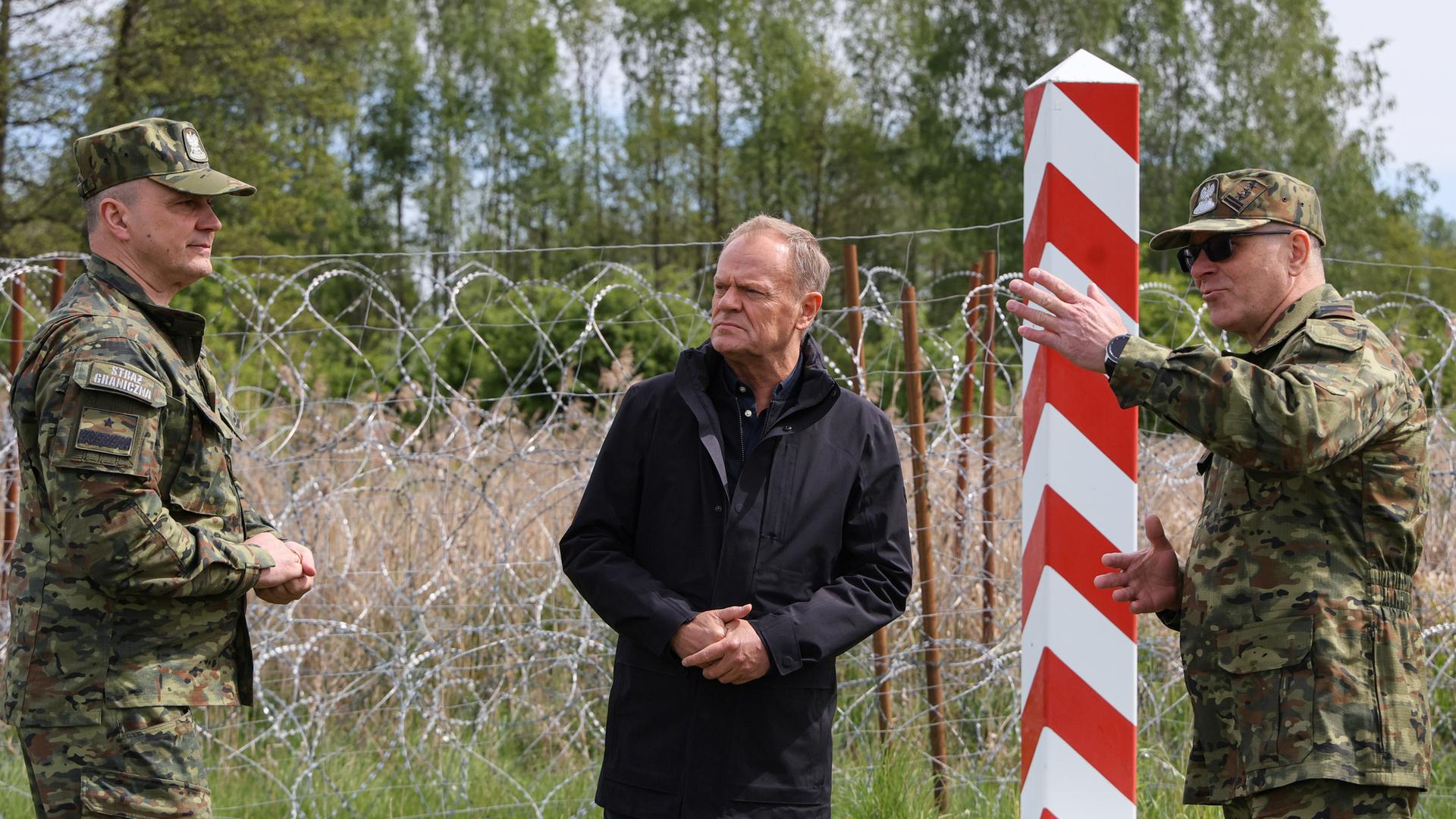 Polen, Ozierany Wielkie: Donald Tusk (M), Ministerpräsident von Polen, der Oberbefehlshaber des Grenzschutzes, Generalmajor Robert Bagan (l) und der stellvertretende Befehlshaber des Grenzschutzes in Podlachien, Oberstleutnant Marek Sochanski, sprechen bei einem Besuch an der Grenze zu Belarus. Archivbild